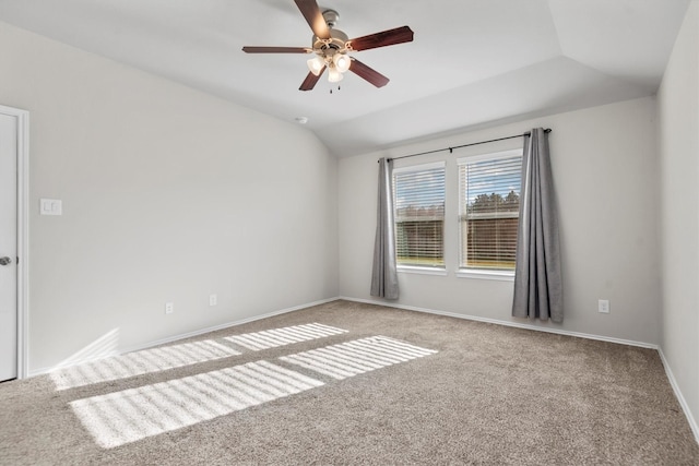 carpeted spare room featuring vaulted ceiling and ceiling fan