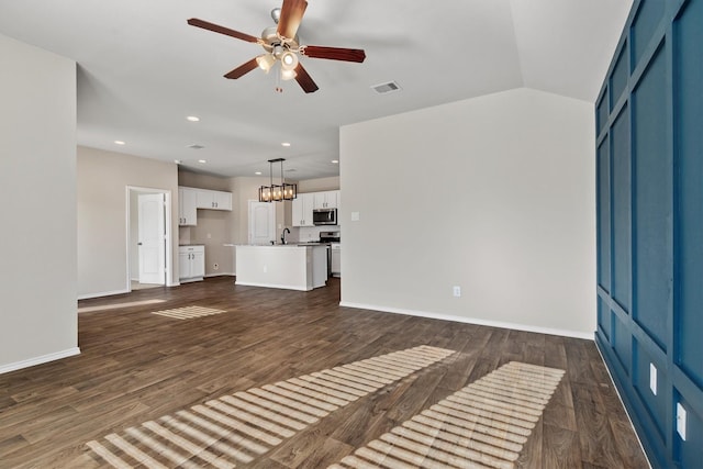 unfurnished living room with ceiling fan, dark wood-type flooring, and sink