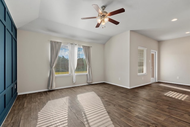 spare room featuring dark hardwood / wood-style floors, ceiling fan, and vaulted ceiling