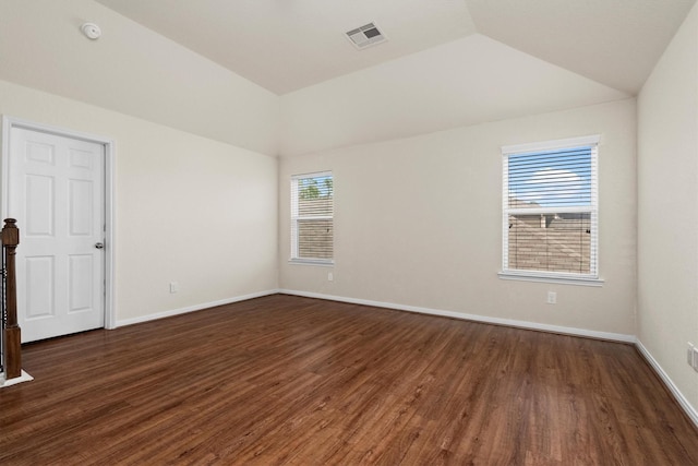 empty room with dark hardwood / wood-style floors and lofted ceiling