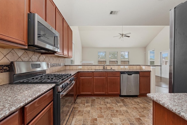 kitchen with lofted ceiling, sink, decorative backsplash, ceiling fan, and stainless steel appliances