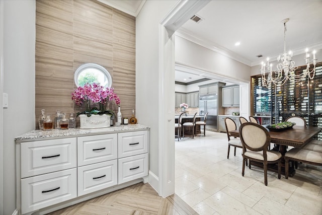 dining space with ornamental molding and an inviting chandelier