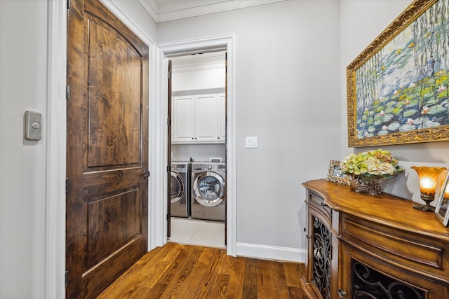 washroom with dark hardwood / wood-style flooring, cabinets, separate washer and dryer, and ornamental molding