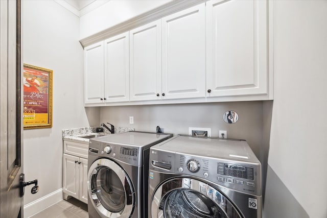 washroom featuring cabinets, sink, ornamental molding, light tile patterned flooring, and washing machine and clothes dryer