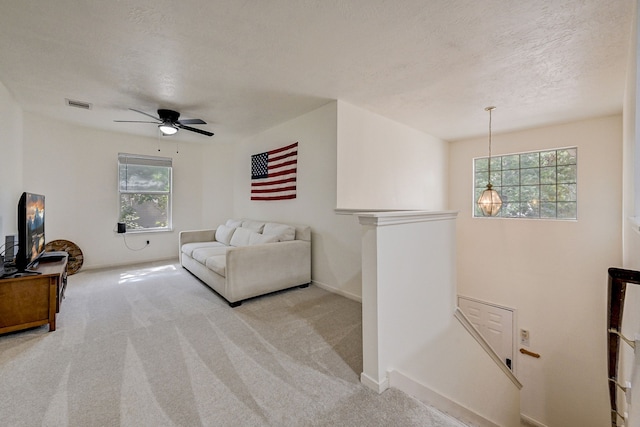 carpeted living room featuring a textured ceiling, plenty of natural light, and ceiling fan