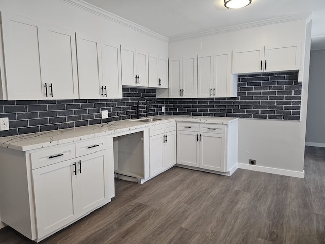 kitchen with backsplash, dark wood-type flooring, crown molding, sink, and white cabinetry