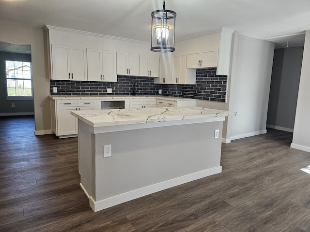 kitchen featuring white cabinets, a kitchen island, and light stone countertops