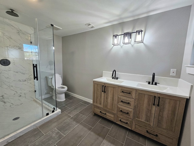 bathroom with vanity, toilet, and a shower with door