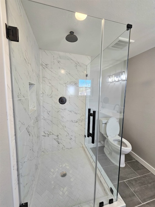 bathroom with tile patterned floors, toilet, and an enclosed shower