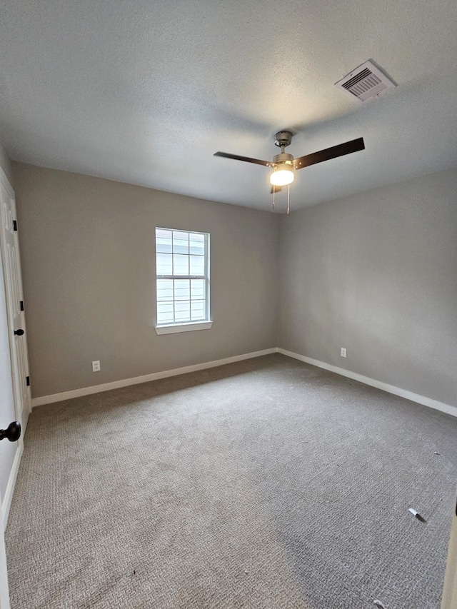 carpeted spare room featuring a textured ceiling and ceiling fan