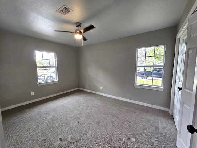 carpeted spare room featuring a textured ceiling and ceiling fan