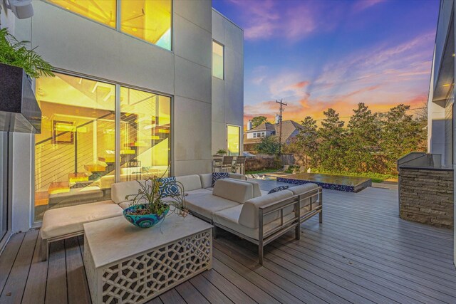 deck at dusk featuring an outdoor hangout area