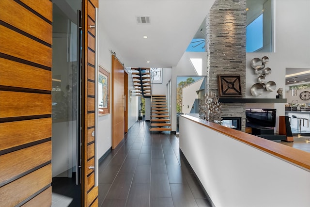 corridor with recessed lighting, visible vents, stairway, a high ceiling, and a sink