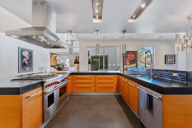 kitchen with appliances with stainless steel finishes, dark countertops, island exhaust hood, and a sink