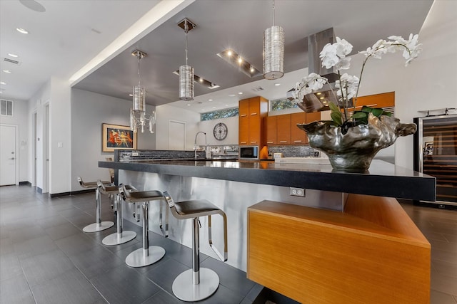 kitchen featuring dark countertops, visible vents, backsplash, and recessed lighting