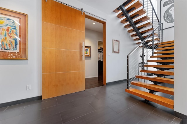 stairs with baseboards and a barn door