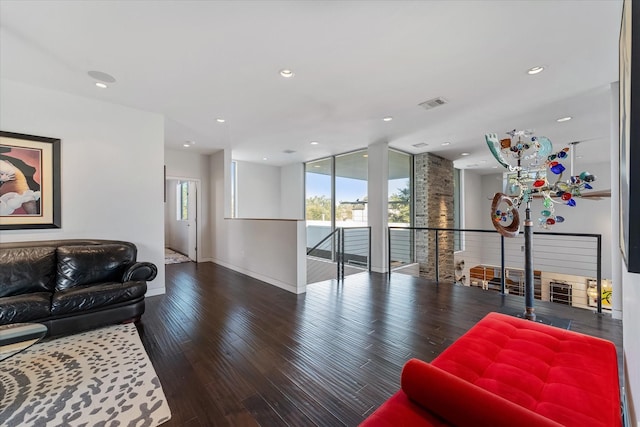 living area featuring wood-type flooring, visible vents, a wall of windows, and recessed lighting