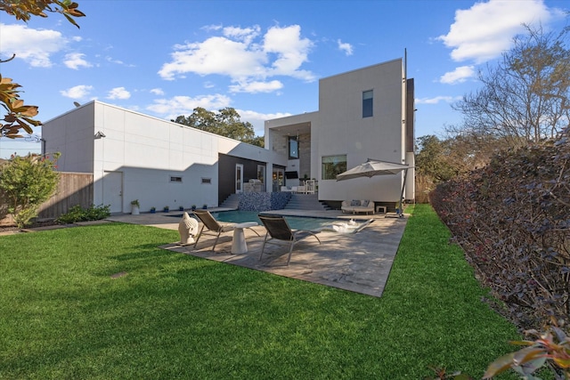 rear view of house featuring a yard, fence, stucco siding, and a patio