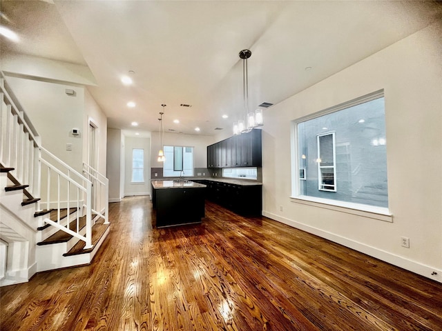 kitchen featuring a kitchen island, sink, dark wood-type flooring, and a wealth of natural light