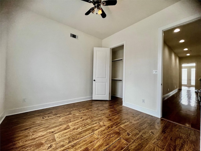 unfurnished bedroom featuring french doors, a closet, dark hardwood / wood-style floors, and ceiling fan