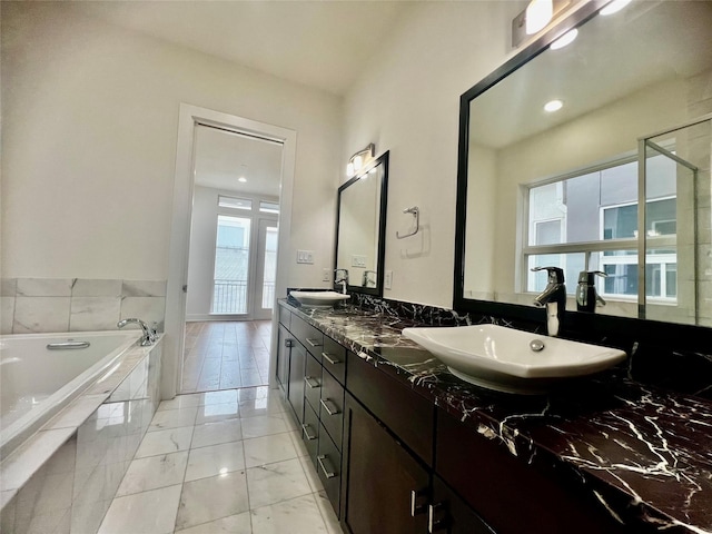 bathroom featuring vanity and a relaxing tiled tub