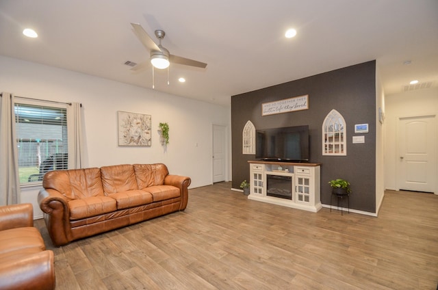 living room with light hardwood / wood-style floors and ceiling fan