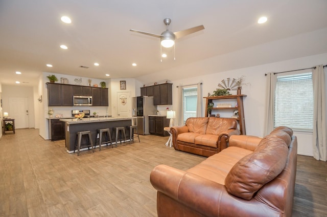 living room featuring ceiling fan and light hardwood / wood-style floors