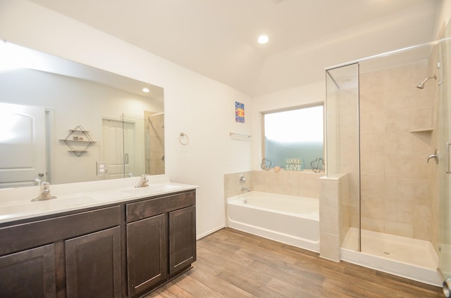 bathroom featuring plus walk in shower, hardwood / wood-style floors, vanity, and vaulted ceiling