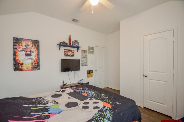 bedroom featuring dark hardwood / wood-style floors, vaulted ceiling, and ceiling fan