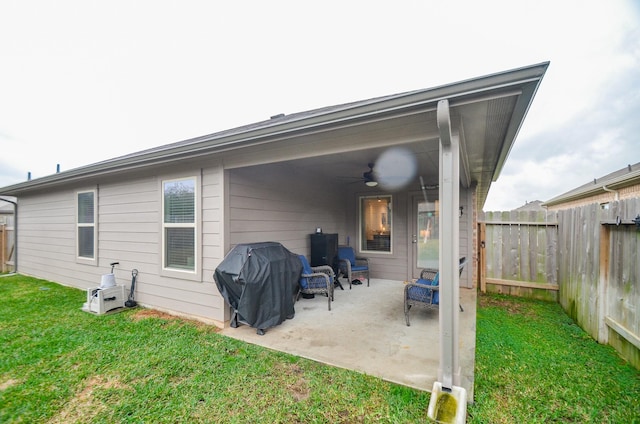 back of property featuring ceiling fan, a patio area, and a lawn