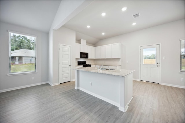 kitchen featuring sink, a center island with sink, white cabinetry, and black appliances