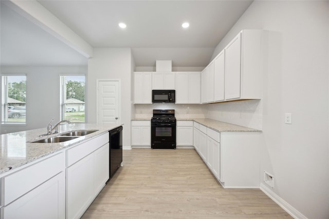 kitchen featuring black appliances, sink, light stone countertops, light wood-type flooring, and white cabinetry