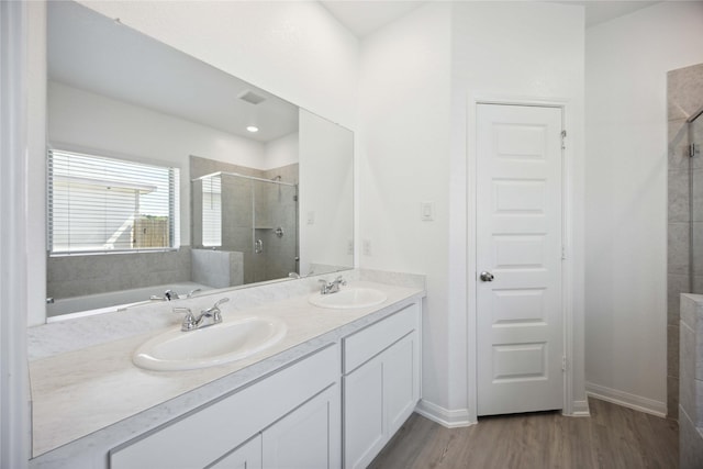 bathroom featuring hardwood / wood-style floors, vanity, and separate shower and tub