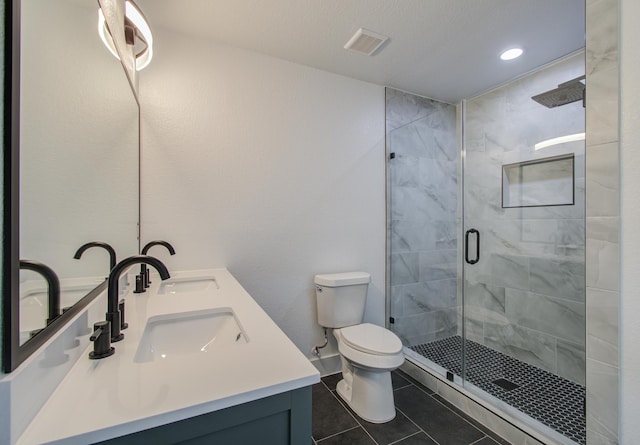 bathroom with tile patterned flooring, vanity, toilet, and a shower with door