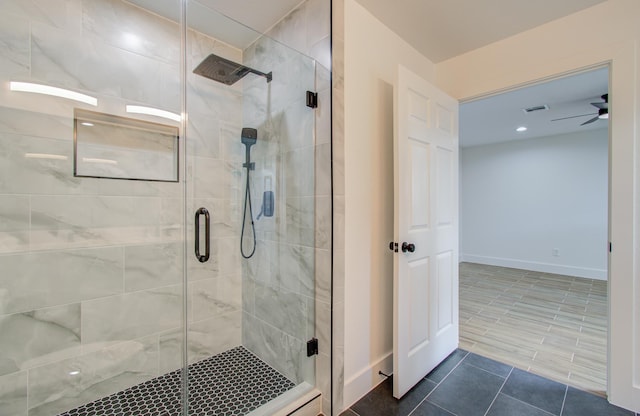 bathroom featuring ceiling fan and an enclosed shower