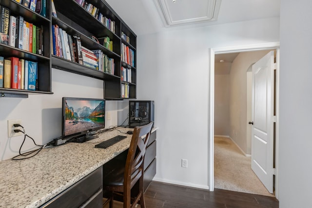 office space with built in desk and dark wood-type flooring