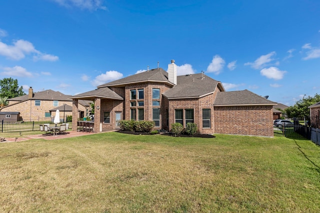 rear view of house featuring a patio area and a yard