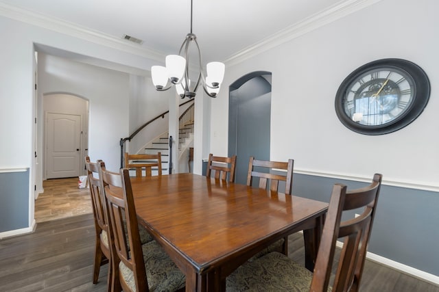 dining room featuring dark wood-type flooring, an inviting chandelier, and ornamental molding