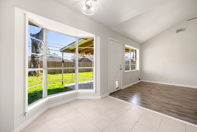 entrance foyer with light tile patterned floors, a wealth of natural light, and lofted ceiling