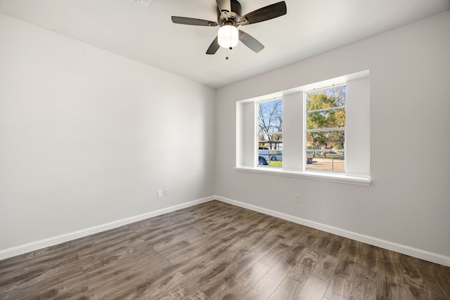 spare room with dark hardwood / wood-style floors and ceiling fan