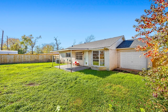 back of property with a lawn, cooling unit, a garage, and a patio