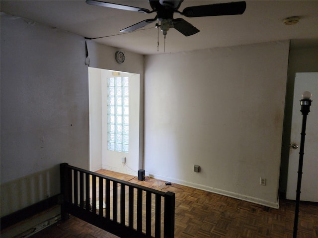 spare room with ceiling fan and dark parquet floors