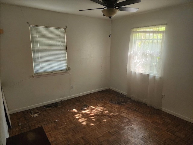 spare room with ceiling fan and dark parquet flooring