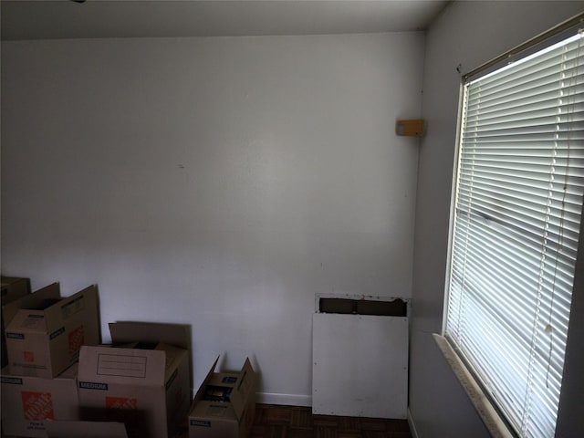 empty room with dark parquet floors and a healthy amount of sunlight