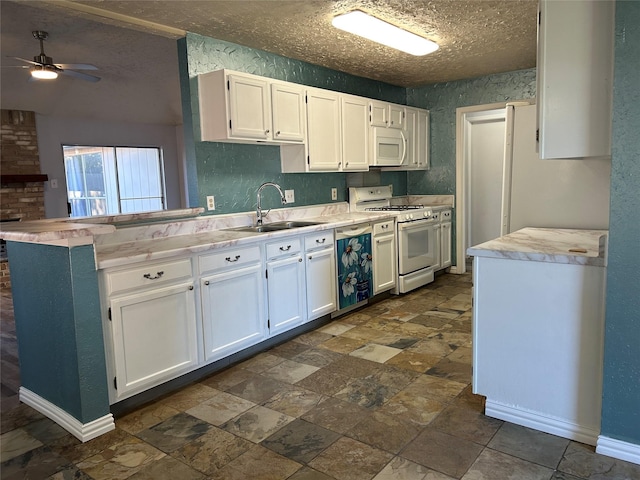 kitchen with white cabinets, kitchen peninsula, white appliances, and sink