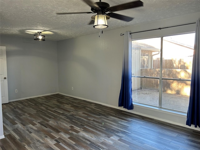 empty room with ceiling fan, plenty of natural light, dark wood-type flooring, and a textured ceiling