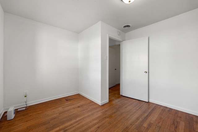 unfurnished room with wood-type flooring