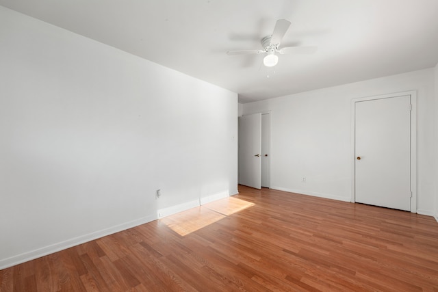 empty room with ceiling fan and light hardwood / wood-style flooring