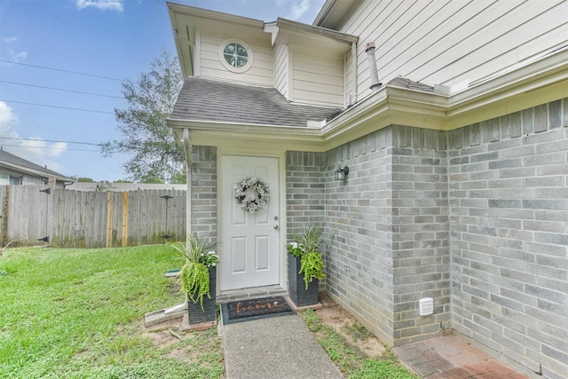 view of exterior entry featuring a yard