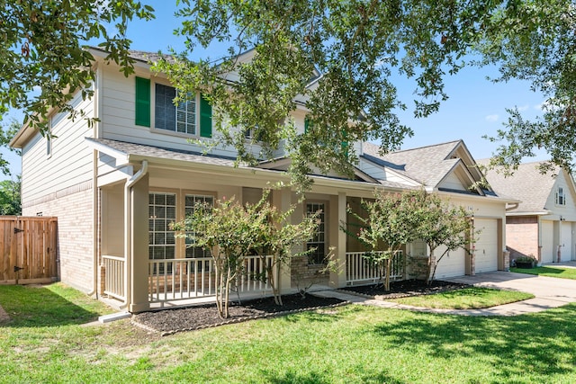 view of front of home with covered porch, a garage, and a front lawn